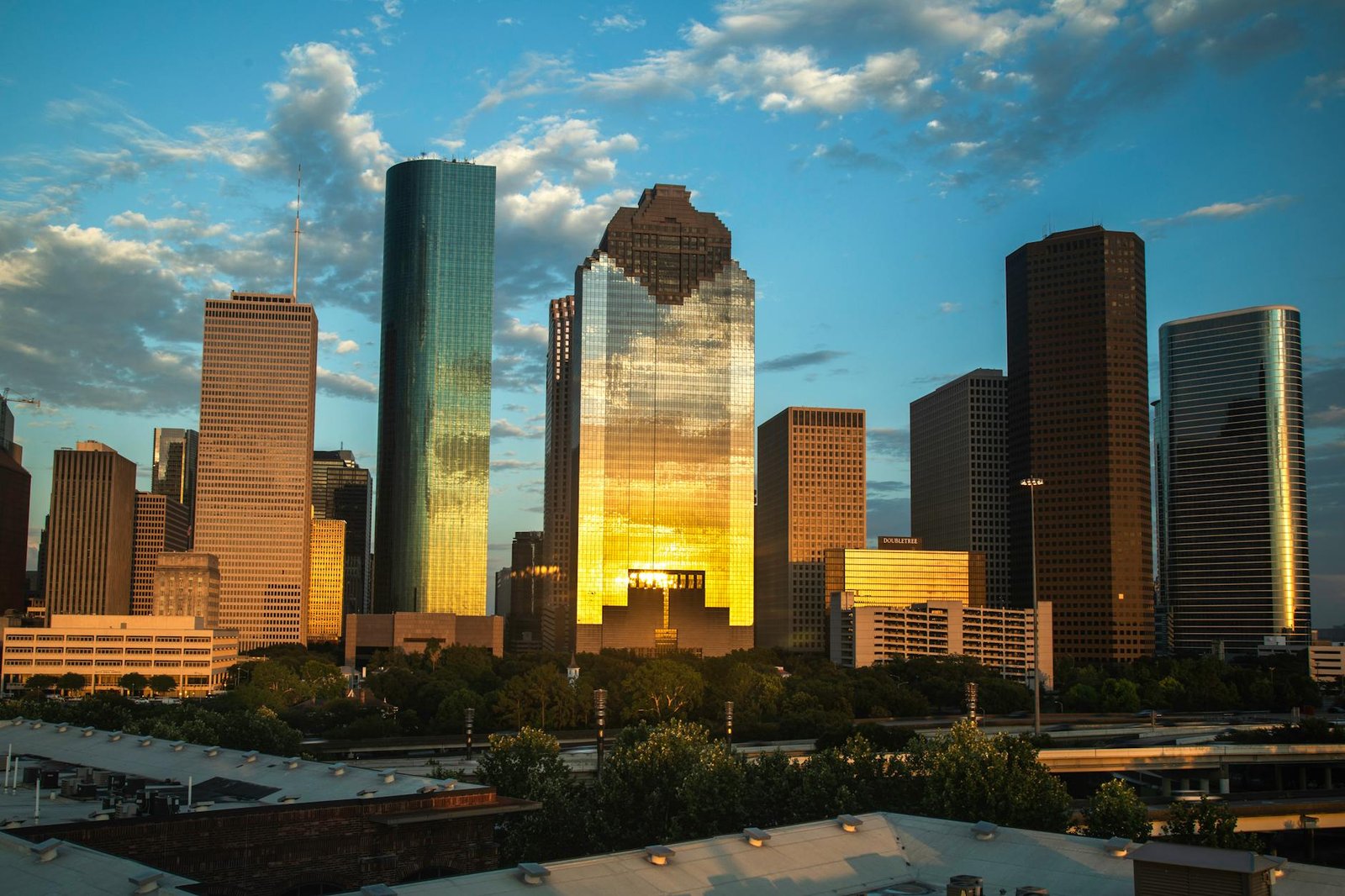 View of Houston's downtown skyline with a beautiful sunset reflection on skyscrapers.