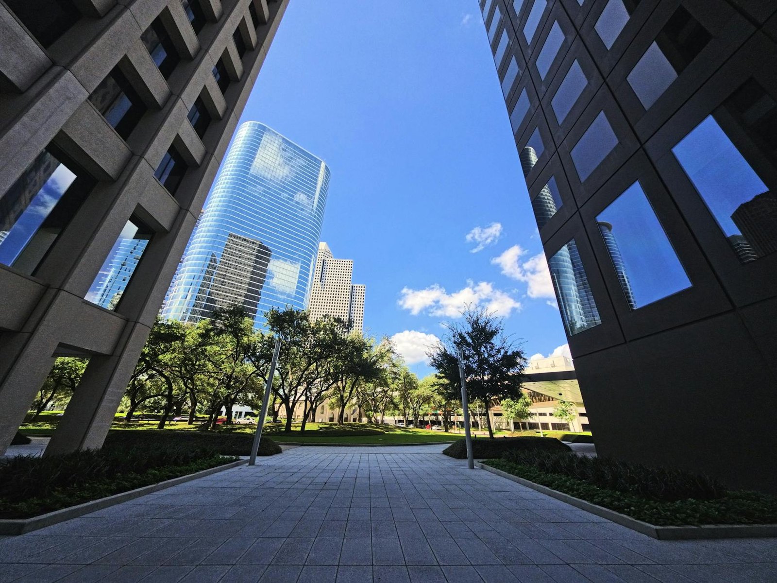 Modern skyscrapers framing the vibrant Houston skyline under a bright blue sky.