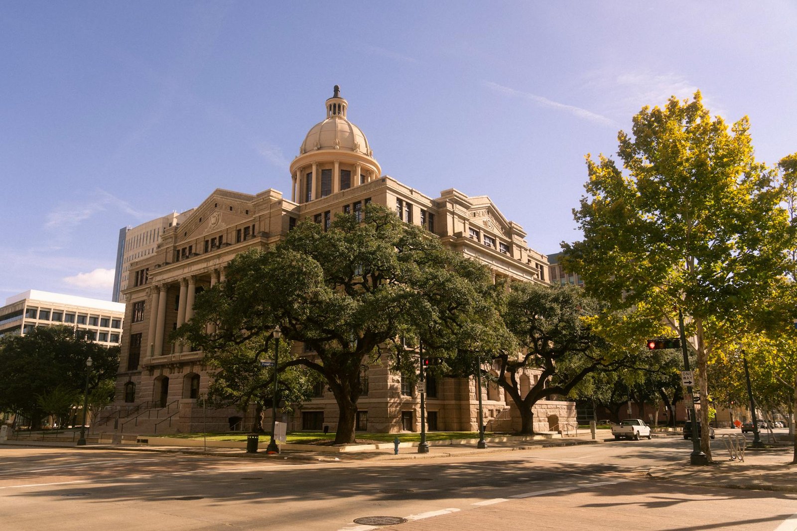 Stunning view of a historic courthouse building with trees, in downtown Houston, Texas.