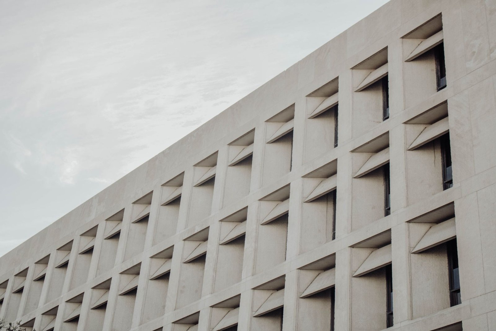 Low-angle view of a modern concrete building facade in Austin, TX.
