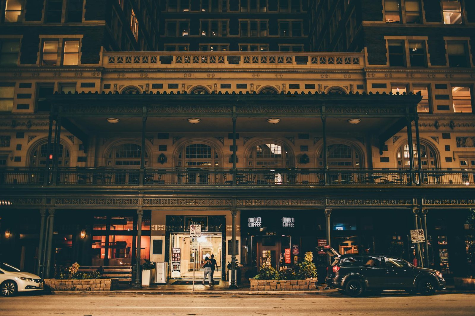 A beautifully illuminated historic building facade captured at night on a street in Houston, Texas.