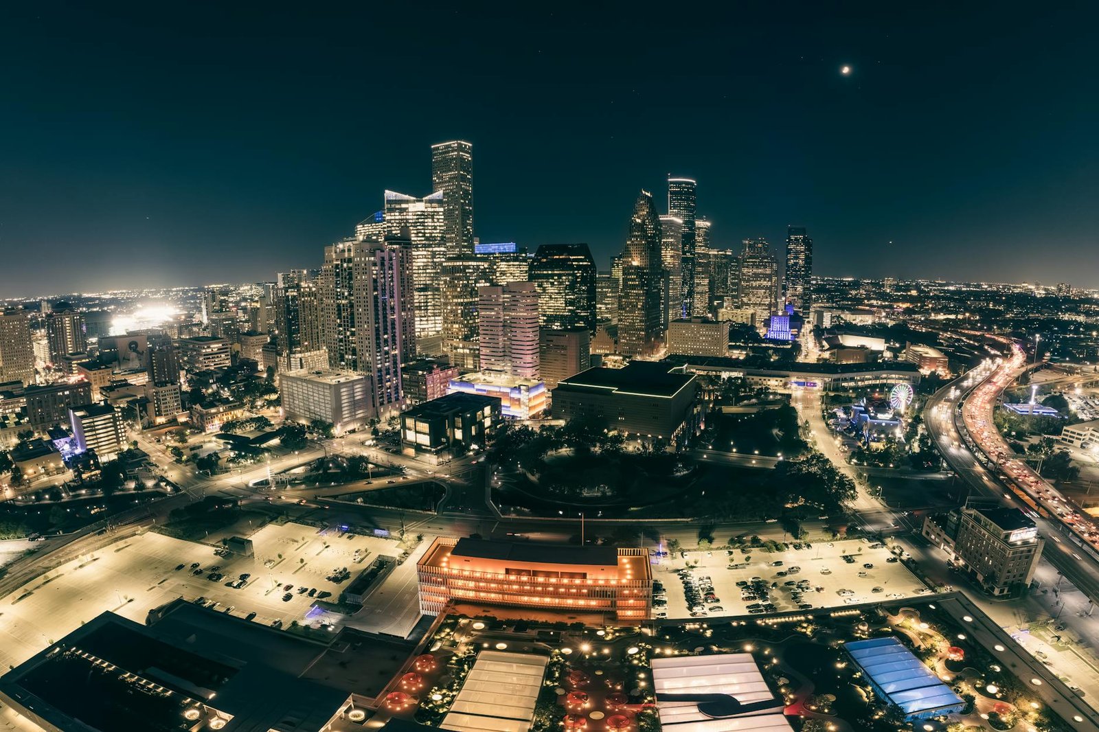 A stunning aerial view of a city skyline illuminated at night, showcasing modern skyscrapers and bustling streets.