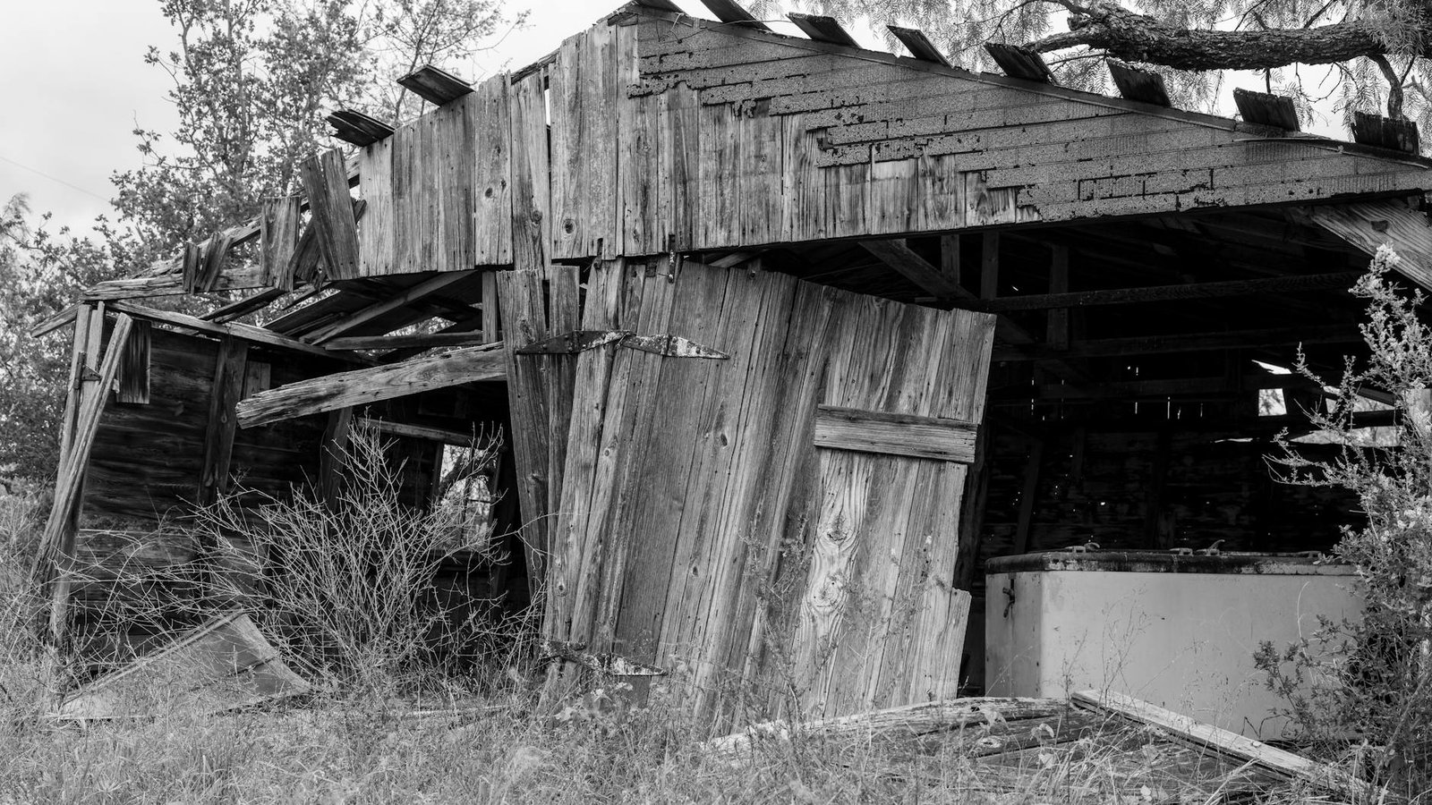 Explore the rustic charm of a weathered barn in Texas, captured in monochrome. Perfect for themes of abandonment and rustic scenery.